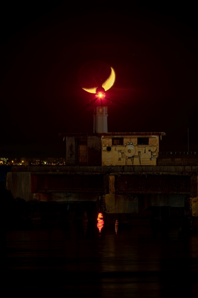 Luna creciente sobre el faro de Almería por Rubén Alguero